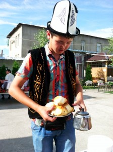 Waiter in a traditional Kyrgyz hat called kalpak serving us spicy and non-spicy samsa