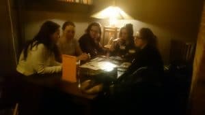 The author learning from four Polish girls how to play "Seven Wonders"